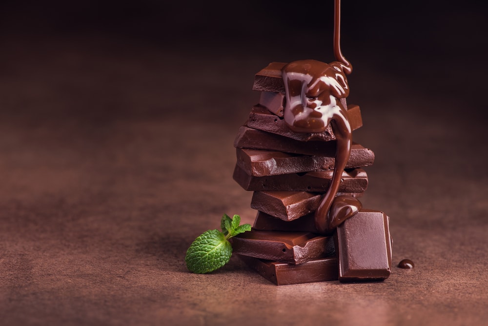 Melted Chocolate Pouring Into A Piece Of Chocolate Bars With Green Mint Leaf On A Table Image Dima Sobkos